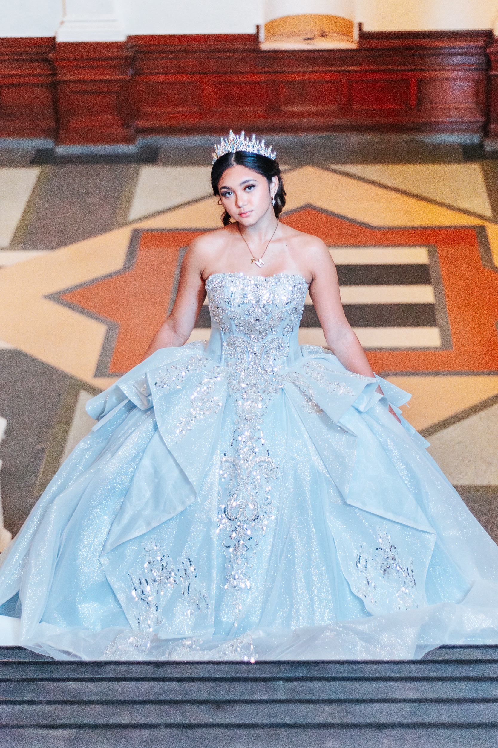 Quinceañera standing on the Texas Lone Star medallion floor inside the State Capitol, photographed by Weddings by Wendi