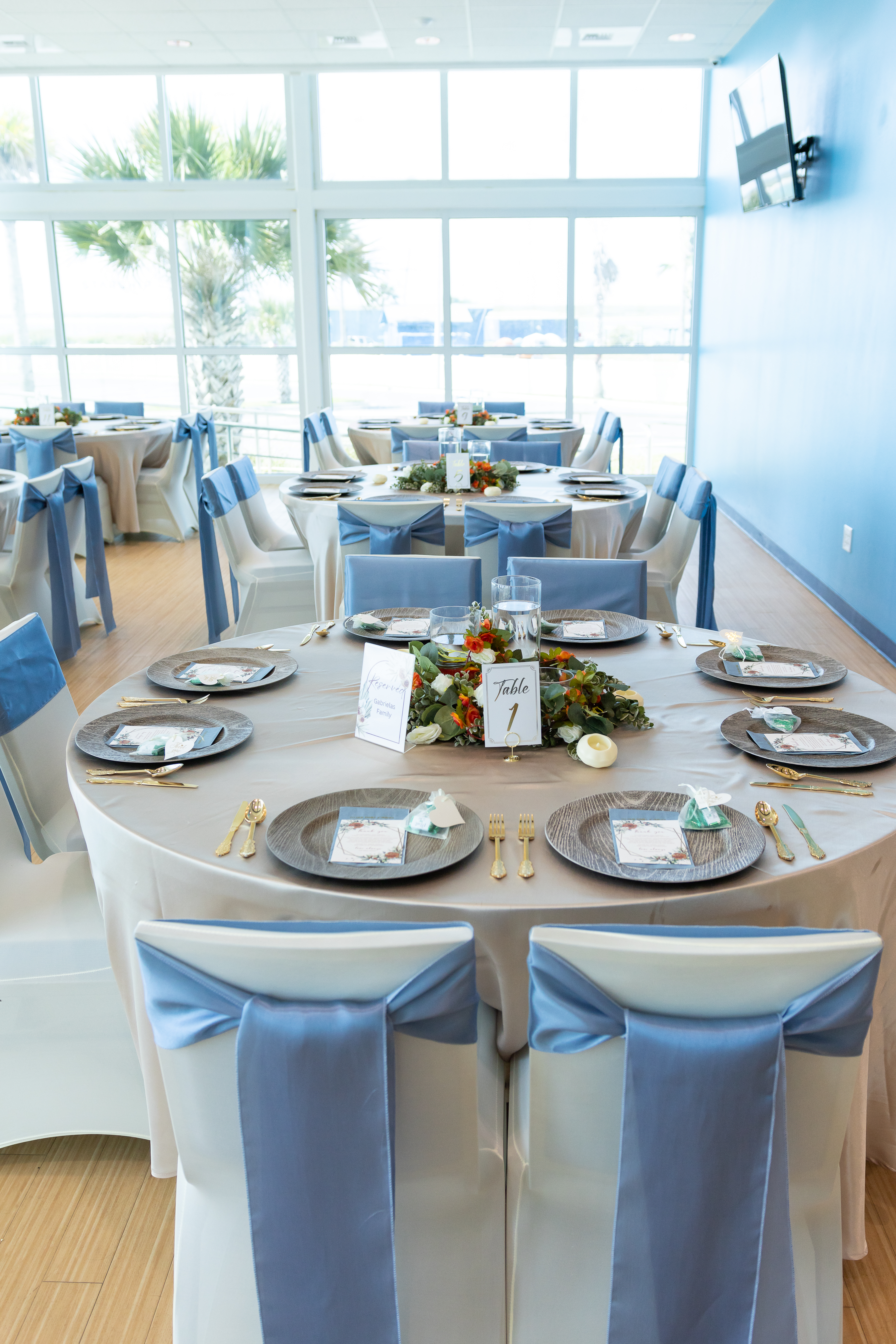Wedding reception detail showing coordinated linens, napkins, and lush floral centerpiece