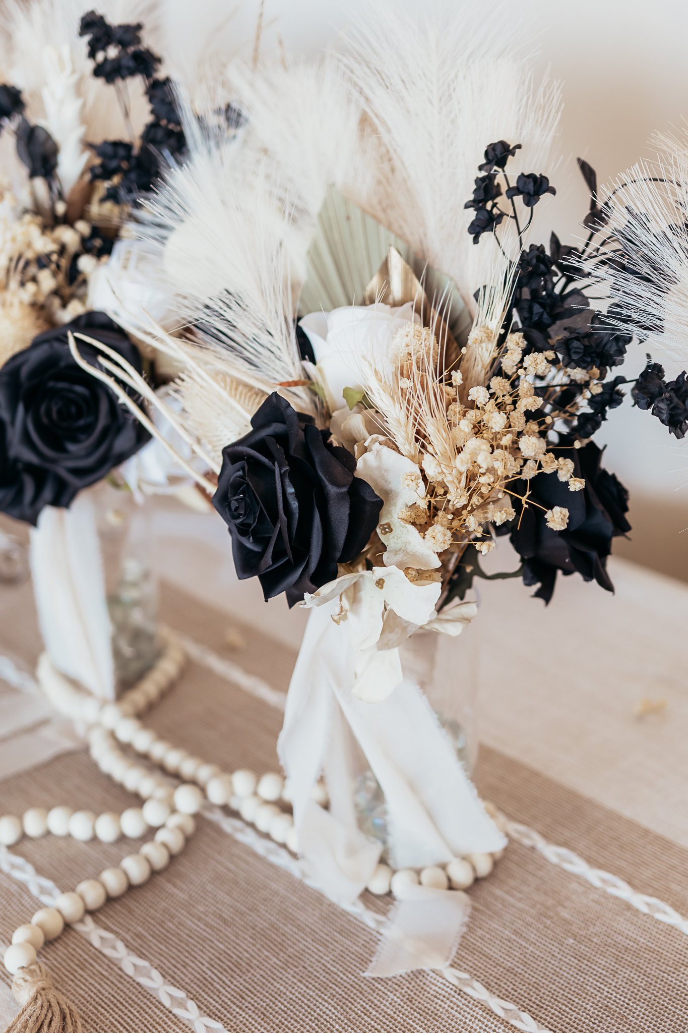 Minimalist reception tablescape with white flowers in textured vase and crystal water glasses